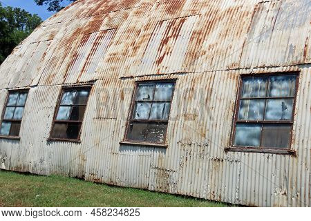 Aging Rusting Quonset Hut Made Of Corrugated Metal With Windows