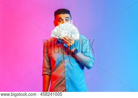 Portrait Of Young Adult Attractive Man In Shirt Standing, Keeking And Demonstrating Fan Of Money And