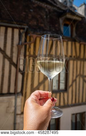 Tasting Of White Grand Cru Classe Chablis Wine With Old French Houses On Background, Burgundy, Franc