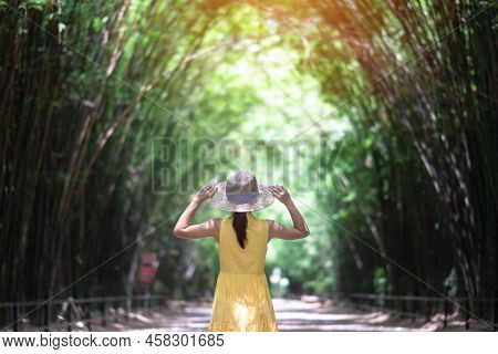 Asian Woman In Yellow Dress And Hat Traveling At Green Bamboo Tunnel, Happy Traveler Walking Chulabh