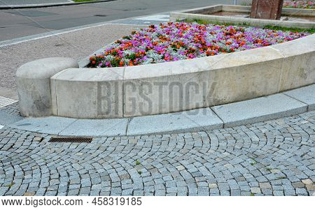Crazy Annual Bed With A Pink-orange Combination Of Flowers. Large Retaining Walls Of Rounded Sandsto