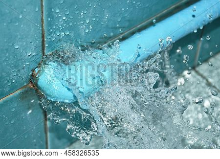 Water Splashing From Broken Plumbing Blue Polythene Pipe Line In Bathroom