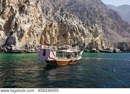 Khasab, Oman - May 27, 2022: Dolphins And Tourist Dhow Boats, Fjords Of Musandam Peninsula.