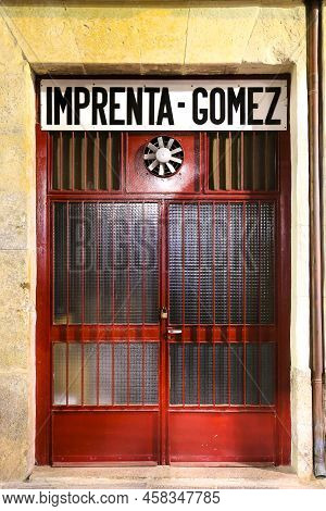 Cartagena, Murcia, Spain- July 17, 2022:red Closed Aluminum Door With Fan Of Printing Shop Called Go