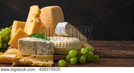 Different Types Of Sarah On A Wooden Background. Assortment Of Cheeses.