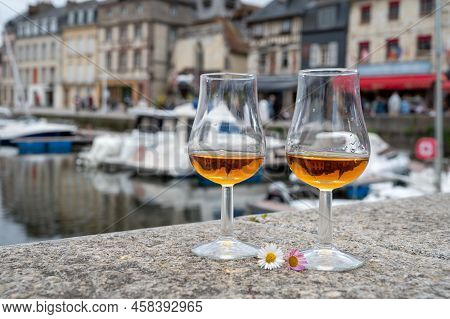 Tasting Of Apple Calvados Drink In Old Honfleur Harbour With Boats And Old Houses On Background, Nor