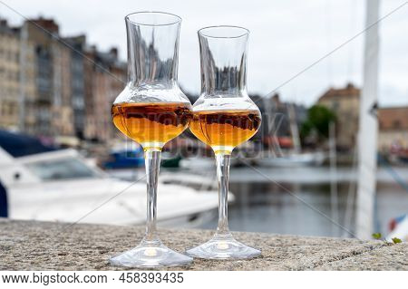 Tasting Of Apple Calvados Drink In Old Honfleur Harbour With Boats And Old Houses On Background, Nor