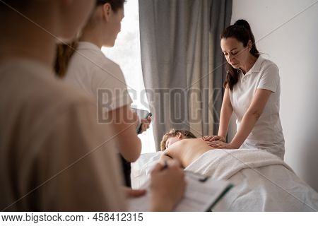 Woman Teacher Helping Student Training To Become Masseuse, Health Wellness Massage Training