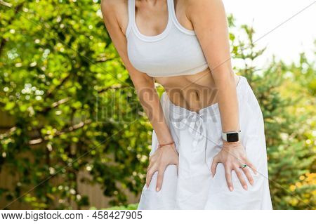 Young Woman Practices Yoga In The Summer Garden. Vacuum Exercise. Nauli Is One Of The Kriyas Or Shat