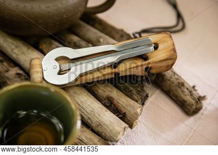 Jews Harp Near Teapot On Wooden Board