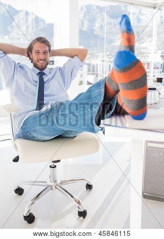 Shoeless designer sparke tilbage på hans skrivebord og smilende