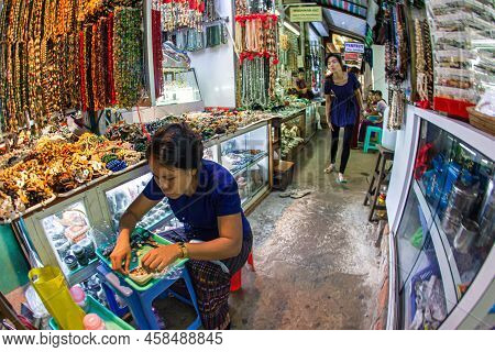 Yangon, Myanmar - December 03 2012 : A Merchant Working At At A Jewelry Booth On Yangon Indoor Bogyo