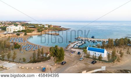 Aerial View Of Coastline Sunset And Landmark White Washed Chapel At Agia Triada Beach, Protaras, Fam