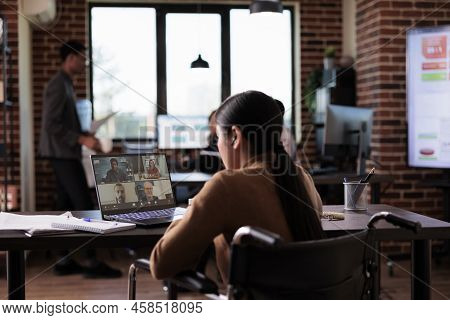 Woman With Chronic Impairment Attending Videocall Meeting In Disability Friendly Office, Chatting Wi