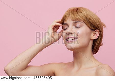 A Close Horizontal Photo Of A Pleasant, Lovely Woman With Perfect Skin, Standing On A Pink Backgroun