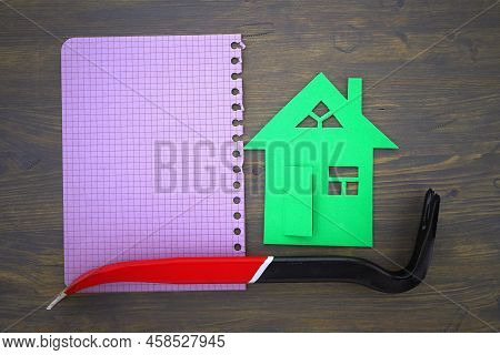 Concept Of Home Renovation Or Construction With Green Cutout Of Model House With Crowbar Or Wrecking