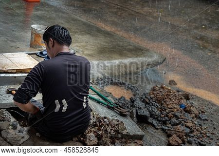 Utility Worker Using Tool To Fixing Broken Water Main For Commercial Building Water Supplies During 
