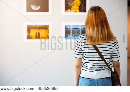 Asian Woman Standing She Looking Art Gallery In Front Of Colorful Framed Paintings Pictures On White