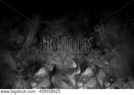 A White Mist Creeping Over The Night Ground. Clouds Of Gray Smoke Rising From Below On A Black Backg