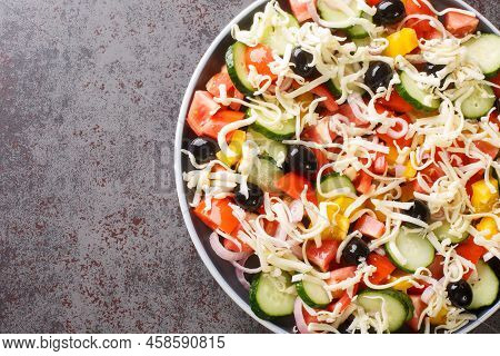 Traditional Shopska Salad With Vegetables, Olives And Cheese Close-up In A Plate On The Table. Horiz