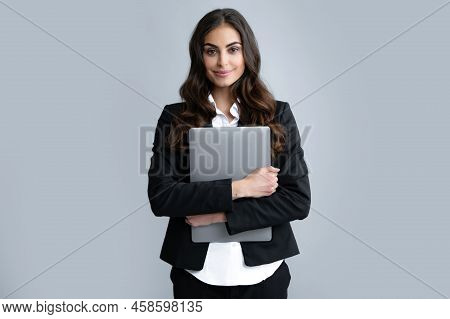 Cheerful Business Woman Standing Over Grey Wall With Laptop Computer. Portrait Of Pretty, Charming, 