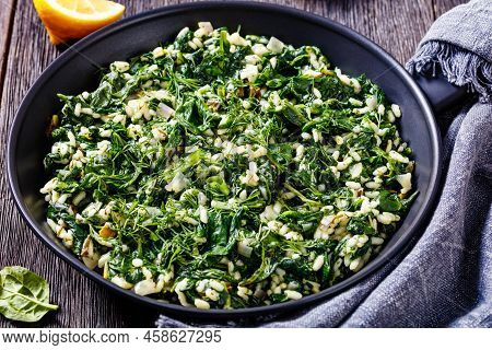 Spanakorizo, Greek Spinach And Rice Pilaf With Lemon, Dill, Spring Onion In Frying Pan On Dark Woode