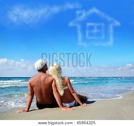 Young Couple On Sea Sand Beach Dreaming About The Own Home