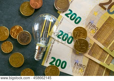 Rising Electricity Prices In Europe.saving Electricity.electricity Cost. Light Bulb, Euro Banknotes 