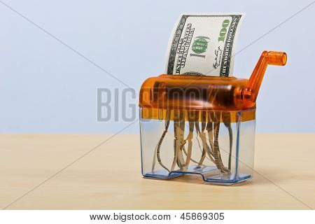 Dollar-Banknote in einem Aktenvernichter