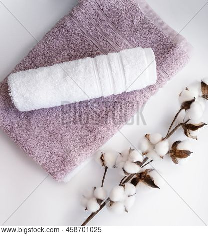 Pink And White Twisted Towel With Cotton Flower Branch On The White Background.
