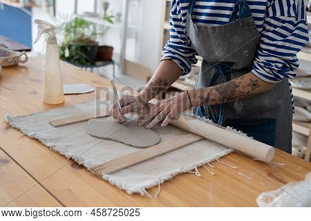Craft Artist Making Object Out Of Clay In Studio, Cropped Shot. Female Ceramic Artist With Tattoo On