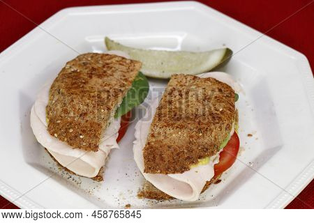 Close-up Of Two Halves Of A Turkey Sandwich With Tomato, Spinach, Mustard And Ground Black Pepper Wi