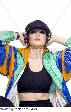 Closeup Portrait Of Young Caucasian Female  Sportwoman In Fitness Outfit And Baseball Cap With Wirel