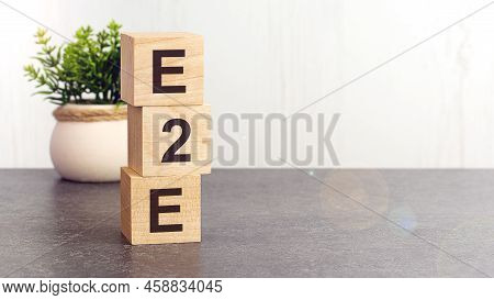 Text E2e On Wooden Dice Standing On Top Of Each Other, Gray Background. E2e - Exchange To Exchange