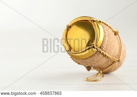 Cork Of Sparkling Wine And Muselet Cap On White Wooden Table, Closeup. Space For Text