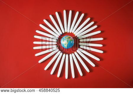 Multi-colored Felt-tip Pens Or Markers And A Globe In A Circle On A Red Background. Drawing And Crea