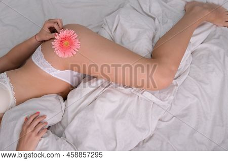 Cropped View Of Young Woman In Lace Panties With Flower Near Underwear On Bed. Epilate Bikini Zone. 