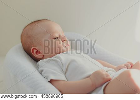 The Baby Is Lying In A Cocoon Of Copy Space . The Baby Is 0-3 Months Old. A Contented Infant. An Art