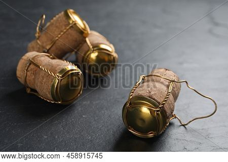 Corks Of Sparkling Wine And Muselet Caps On Black Table