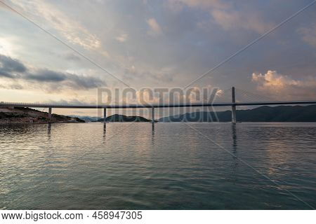Beautiful Bridge Across The Sea To Peljesac Peninsula In Croatia. There Are Dramatic Clouds In The S