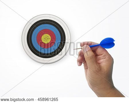 Human Hand Is Throwing The Darts Target To The Darts Board. A Man's Hand Throws A Dart At The Target