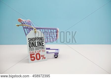 Shopping Online Sale 50% Text Message On Price Tax With Shoppint Trolley Cart On Blue And Pink Backg