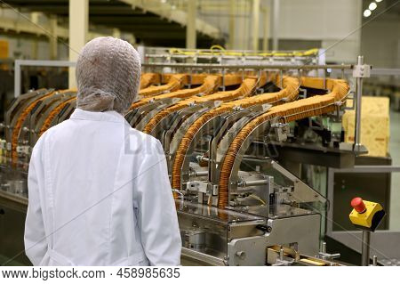 A Woman Controls The Production Process. Large Biscuit Factory. A Line Of Biscuits In A Large Factor