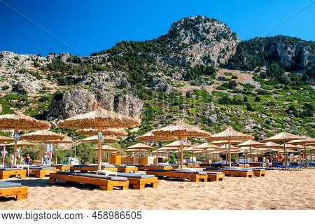 Tsambika, Greece - July 2, 2022: Sunshades And Loungers At Tsambika Beach In Rhodes Island In Greece
