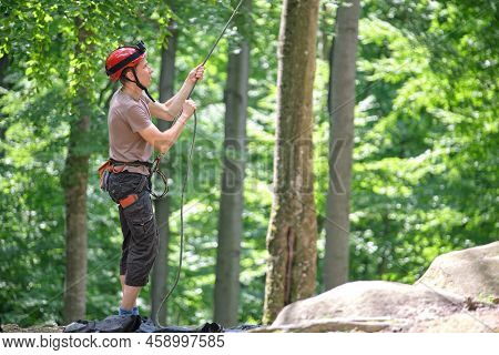 Man Belays His Partner Climber With Belaying Device And Rope. Climbers Handsman Holding Equipment Fo