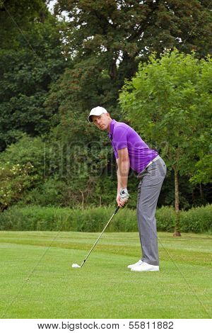 Photo of a golfer addressing the ball and playing a wedge shot into the green. Series of five in the set.