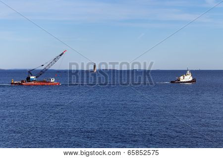 Portland, Maine - Tug boat towing a barge in front of Ram Island Ledge Light