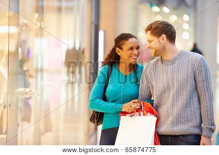 Happy Couple Carrying Bags In Shopping Mall