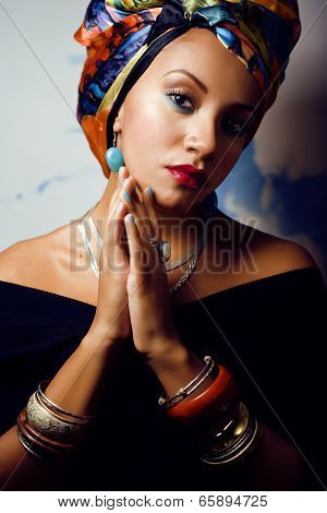 beauty bright african woman with creative make up, shawl on head like cubian woman