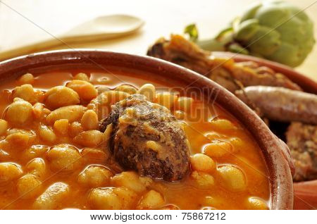 an earthenware bowl with potaje de judias y garbanzos, a traditional spanish legume stew